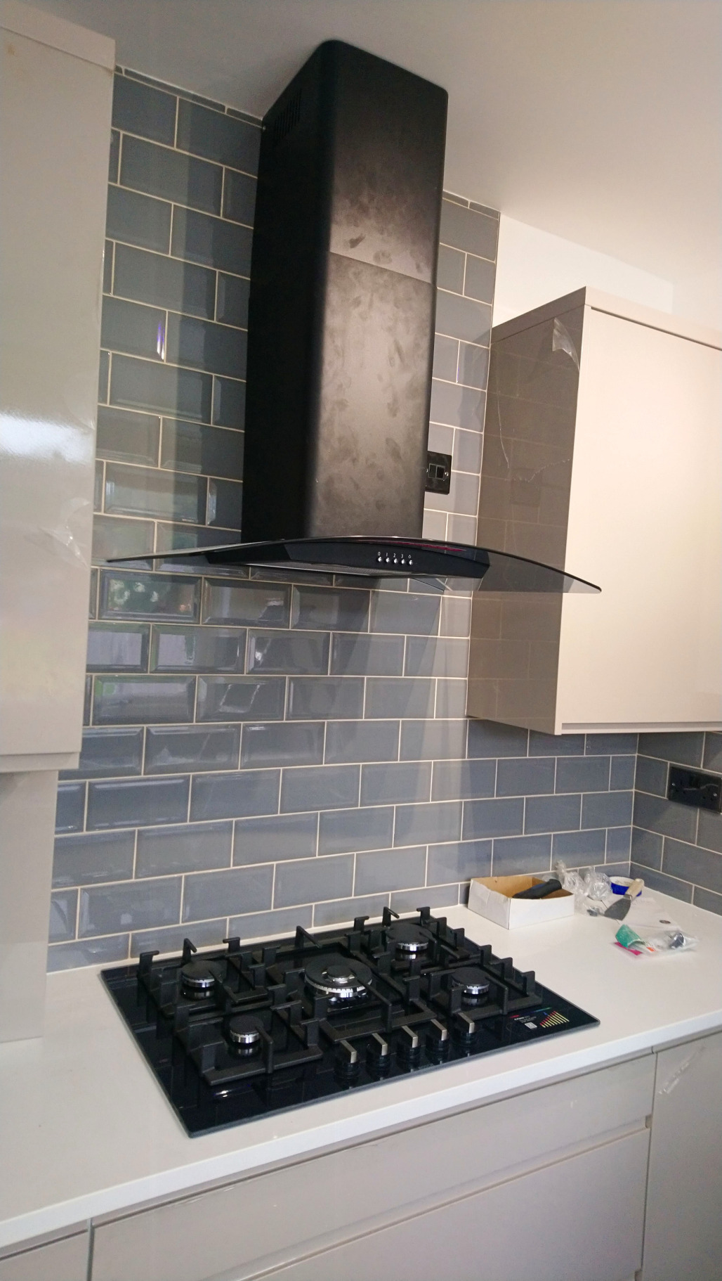 Completed kitchen renovation in Gants Hill with grey metro tiling, white cabinetry and black fittings